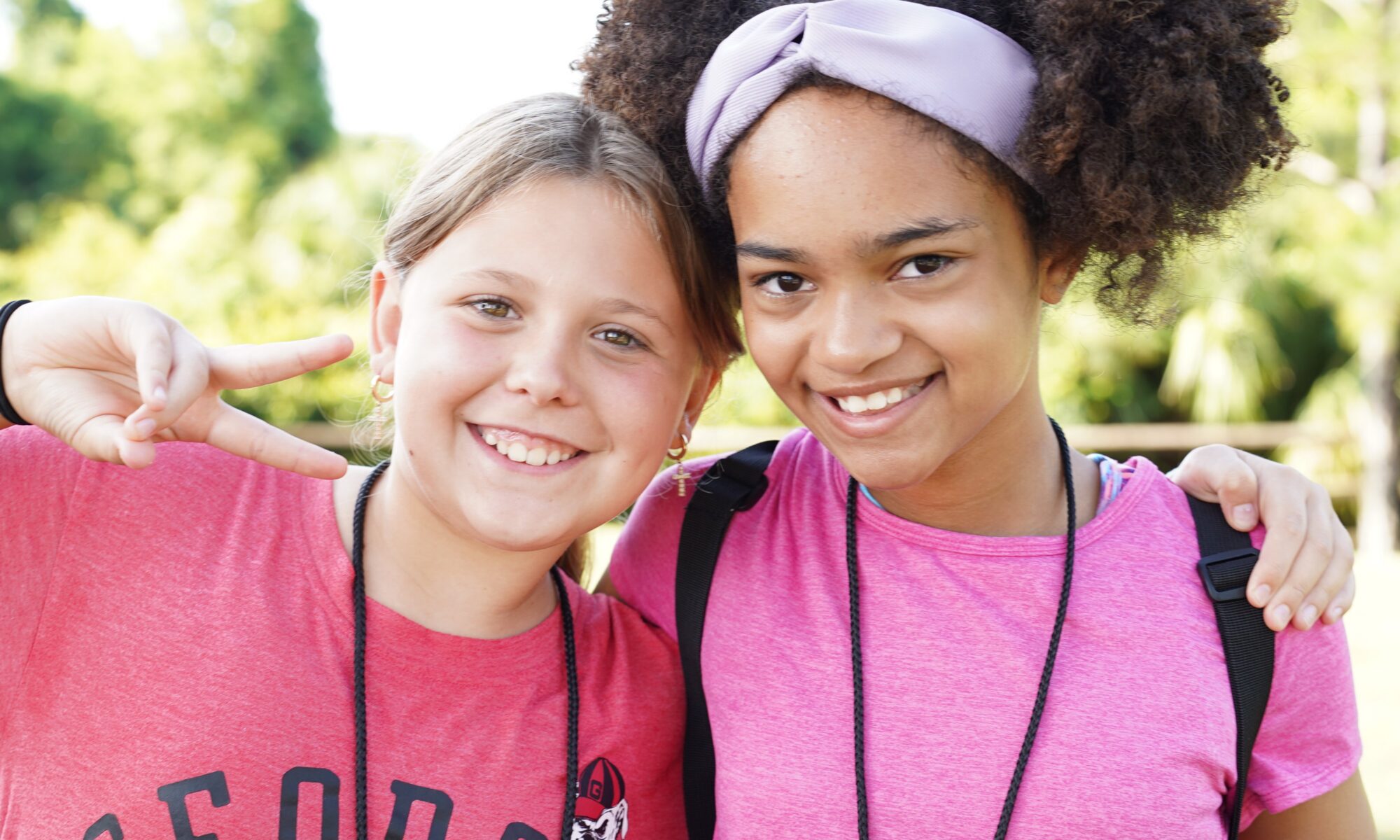 Two youth holding up peace signs while posing for a photo.