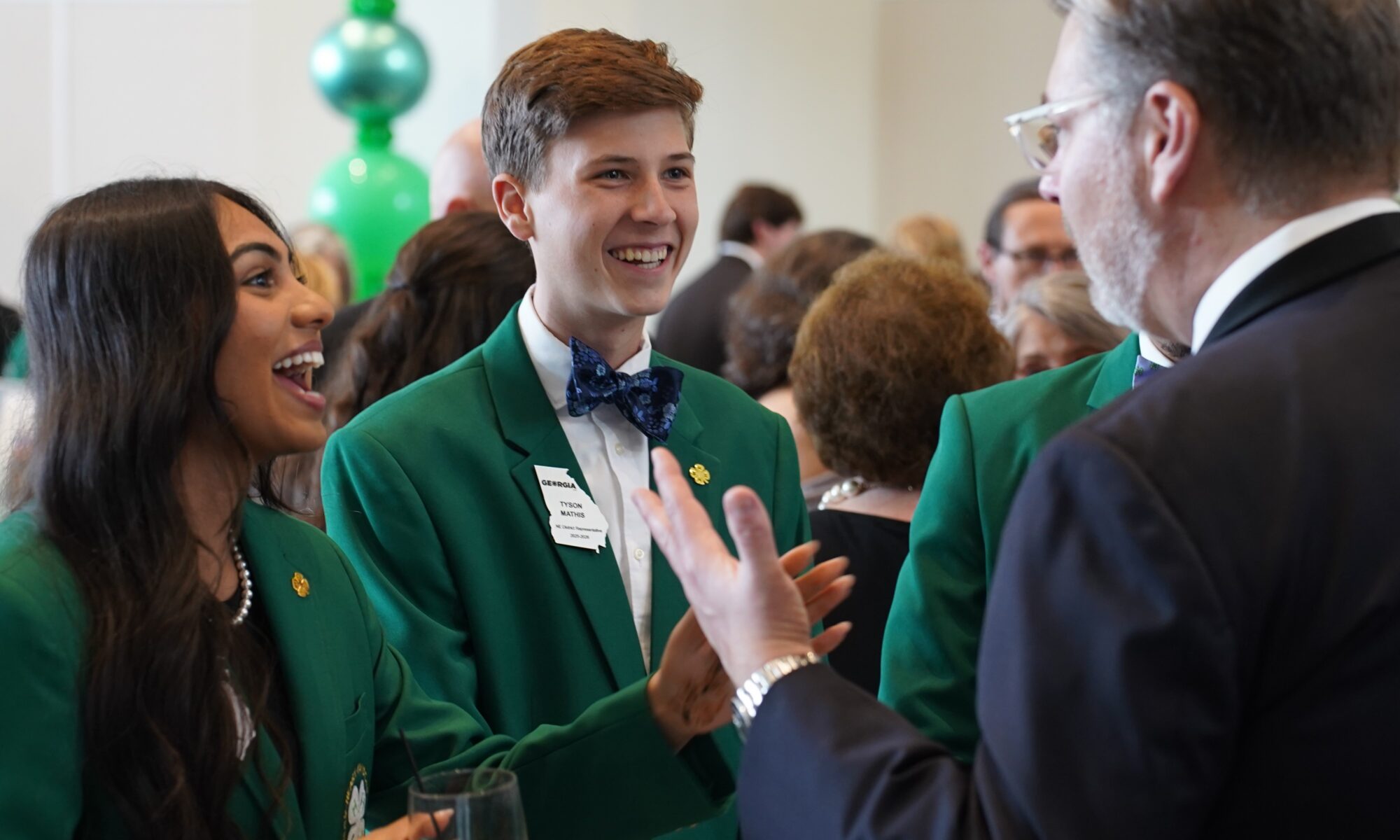 Two Georgia 4-H State Board members having a conversation with an adult.