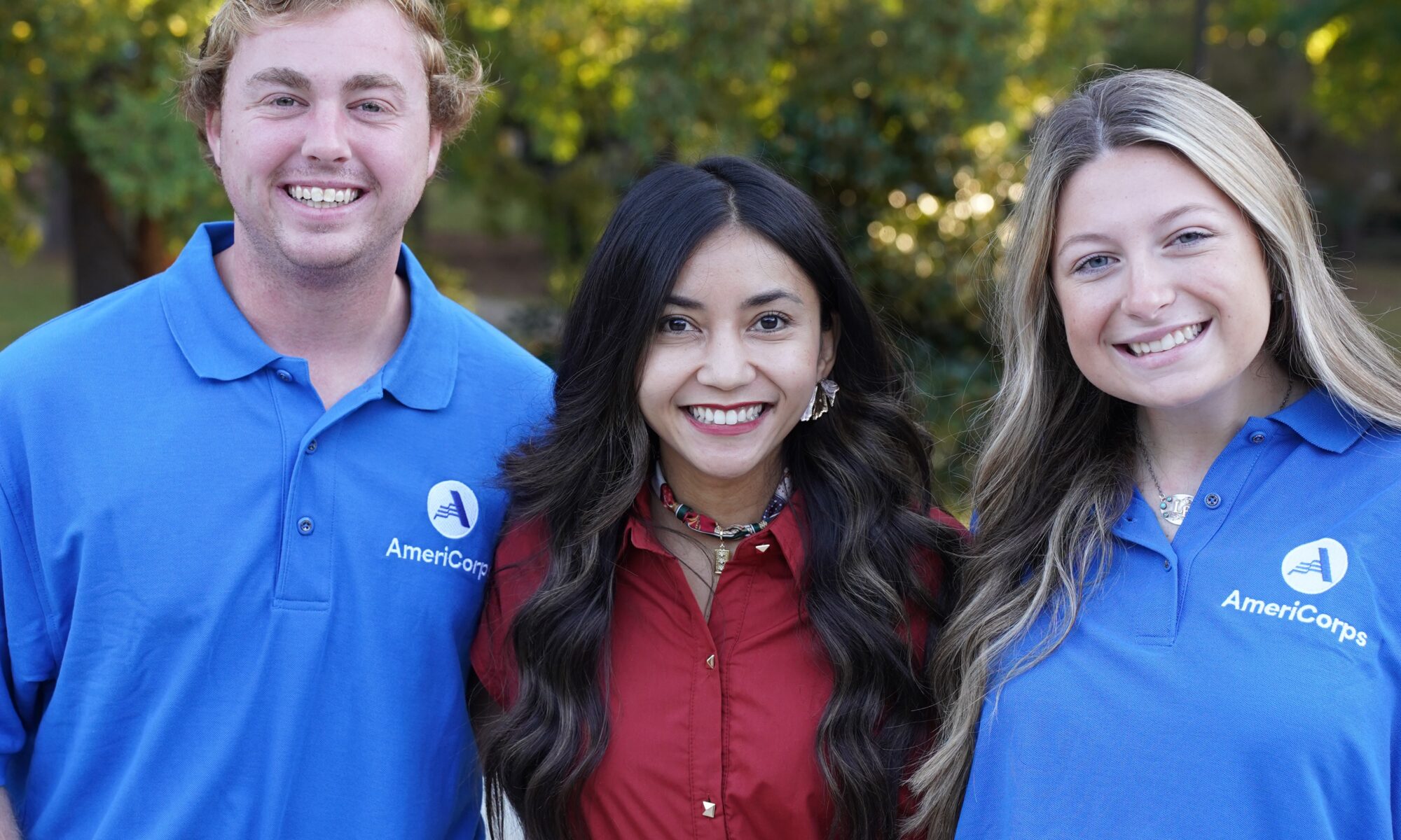 Two Americorps members posing with a Georgia 4-H county agent.