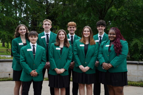 A group of students dressed in green blazers