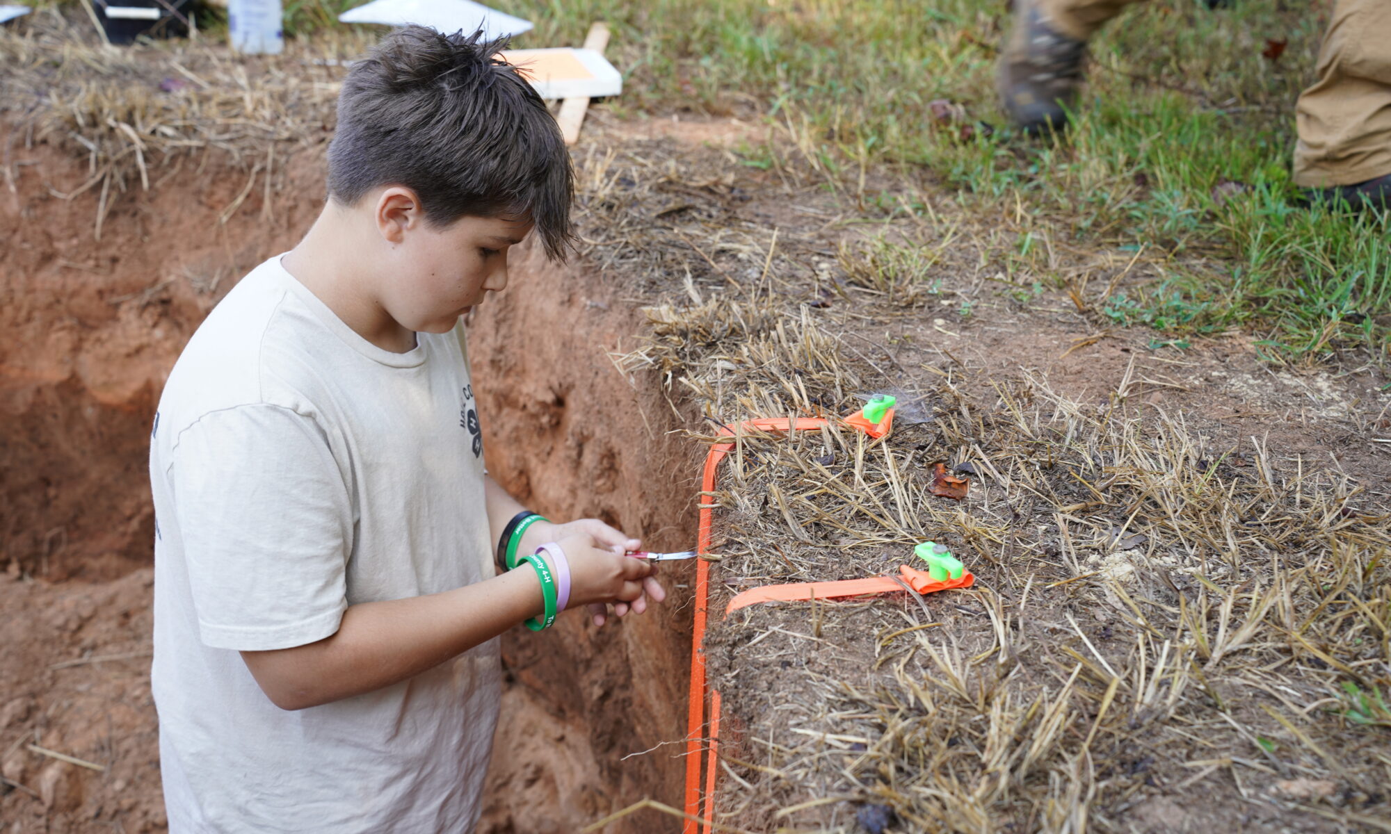 A student using tools to survey the soil during the land judging competition