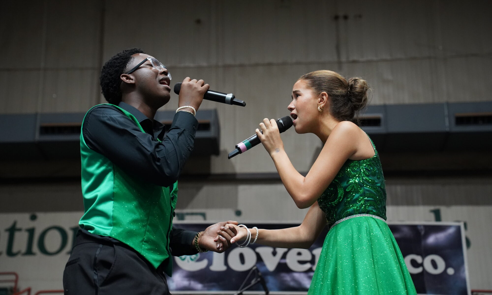 Two singers holding microphones on a stage
